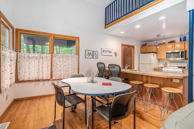 9191 W Ranger Rd, Mears, MI 49436 - dining space featuring light wood-style floors, a high ceiling, and recessed lighting
