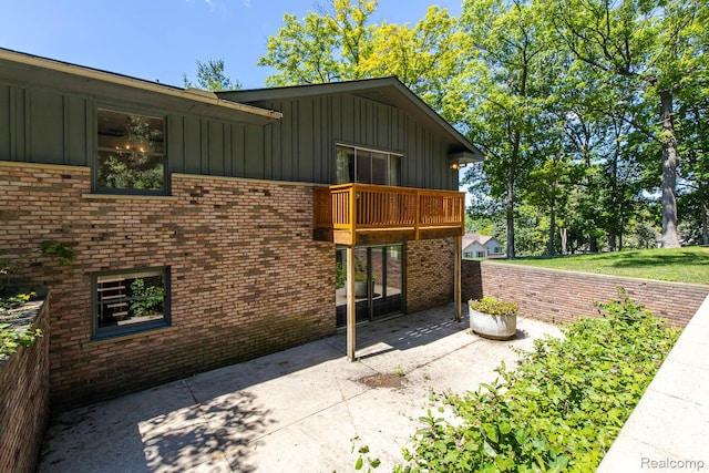 6674 Balmoral Ter, Clarkston, MI 48346 - view of side of home featuring board and batten siding, a balcony, a patio area, and brick siding