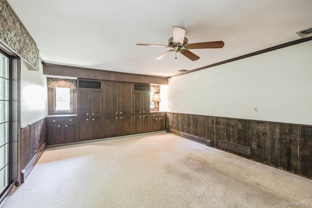 6674 Balmoral Ter, Clarkston, MI 48346 - unfurnished room with wood walls, ceiling fan, wainscoting, ornamental molding, and light carpet