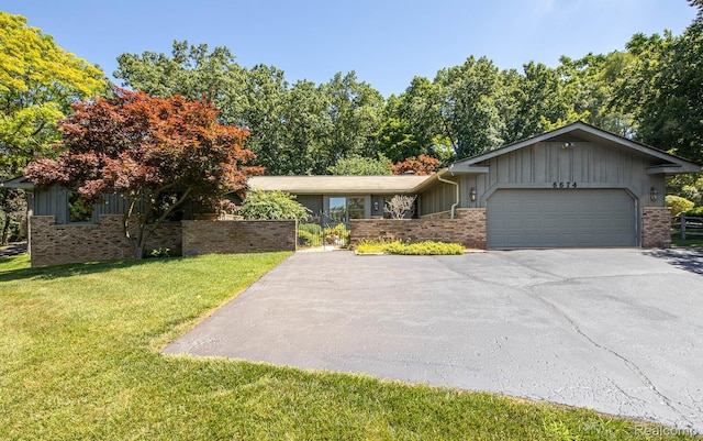 6674 Balmoral Ter, Clarkston, MI 48346 - view of front of property with board and batten siding, brick siding, and driveway