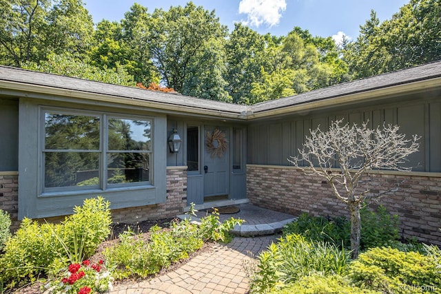 6674 Balmoral Ter, Clarkston, MI 48346 - view of exterior entry featuring board and batten siding and brick siding