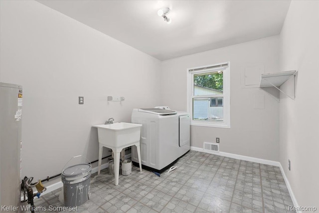 22281 Poinciana St, Southfield, MI 48033 - washroom with washer / dryer, light floors, and gas water heater
