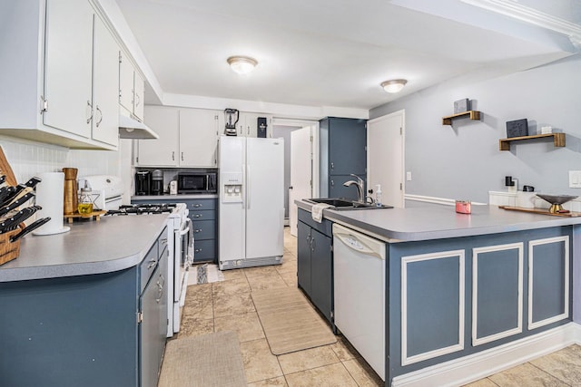 407 W Pine St, Big Rapids, MI 49307 - kitchen with white appliances, blue cabinets, under cabinet range hood, light tile patterned floors, and a peninsula
