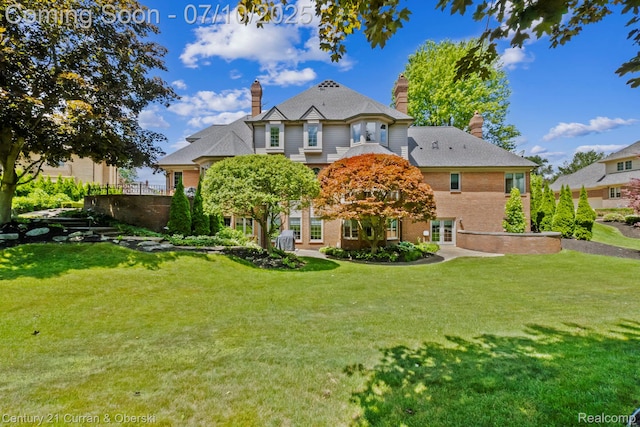 18878 Oak Leaf Ln, Northville, MI 48168 - back of property featuring french doors, a chimney, a yard, and brick siding