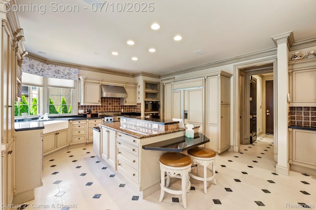 18878 Oak Leaf Ln, Northville, MI 48168 - kitchen featuring cream cabinetry, ventilation hood, a kitchen island, light floors, and backsplash