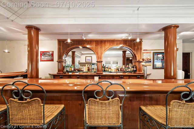 18878 Oak Leaf Ln, Northville, MI 48168 - indoor wet bar featuring decorative columns and hanging light fixtures