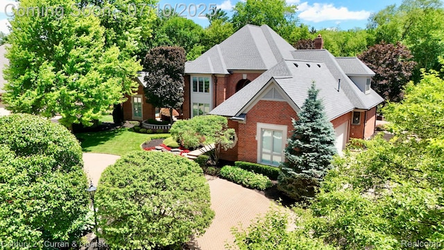 18878 Oak Leaf Ln, Northville, MI 48168 - view of front facade with brick siding, a chimney, and a shingled roof