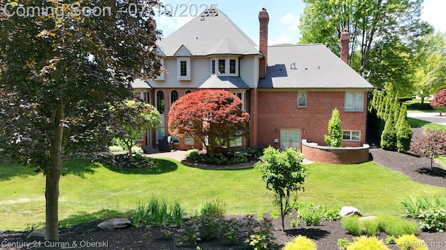 18878 Oak Leaf Ln, Northville, MI 48168 - rear view of house with a chimney, brick siding, and a lawn