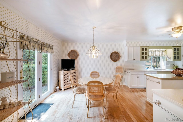 2032 Crestline, Burton, MI 48509 - dining room with wallpapered walls, light wood-style floors, healthy amount of natural light, and a chandelier