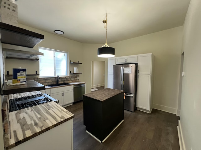 717 Watson St SW, Grand Rapids, MI 49504 - kitchen with appliances with stainless steel finishes, open shelves, butcher block countertops, a kitchen island, and tasteful backsplash