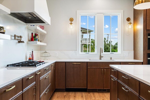 273 Waters Edge Dr, Saint Joseph, MI 49085 - kitchen featuring custom range hood, light countertops, stainless steel gas cooktop, and dark brown cabinets