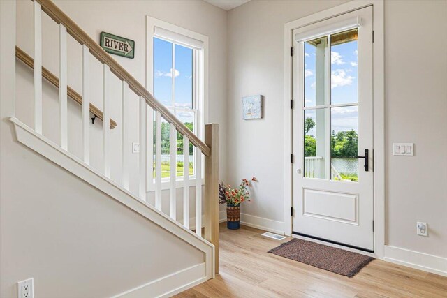 273 Waters Edge Dr, Saint Joseph, MI 49085 - entrance foyer with healthy amount of natural light, light wood finished floors, and stairway