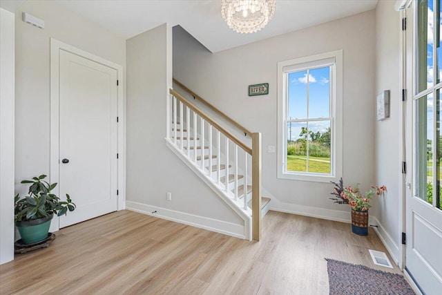 273 Waters Edge Dr, Saint Joseph, MI 49085 - entryway with light wood-type flooring, stairs, and a chandelier