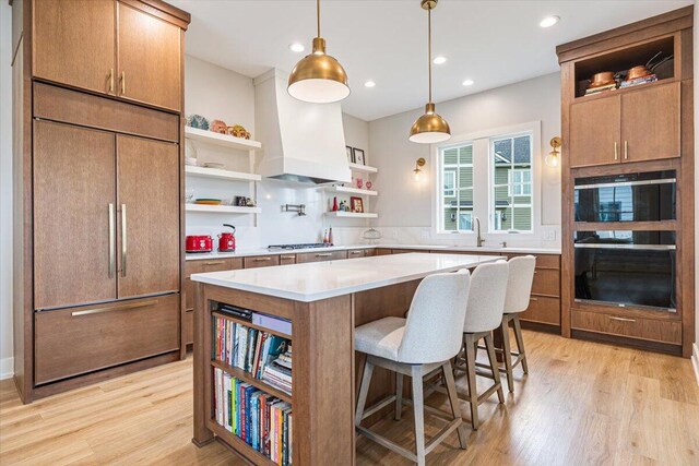 273 Waters Edge Dr, Saint Joseph, MI 49085 - kitchen with open shelves, paneled refrigerator, black oven, light wood-style floors, and light countertops