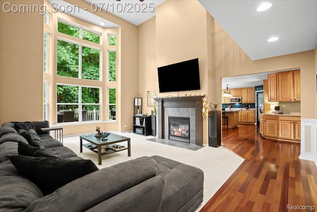 4583 Racewood Dr, Commerce Twp, MI 48382 - living area featuring a towering ceiling, plenty of natural light, a fireplace, recessed lighting, and dark wood-style floors