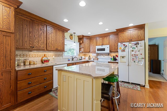 3910 Walker Ave NW, Grand Rapids, MI 49544 - kitchen with white appliances, open shelves, brown cabinets, a kitchen bar, and backsplash