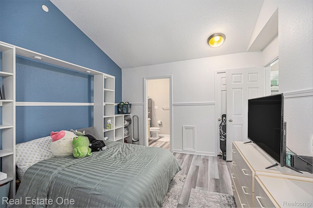 239 Fieldcrest St, Ann Arbor, MI 48103 - bedroom featuring wood finished floors, vaulted ceiling, and ensuite bathroom