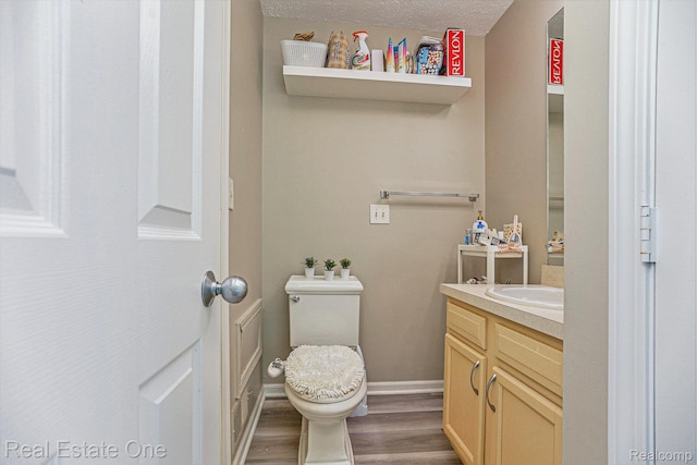 239 Fieldcrest St, Ann Arbor, MI 48103 - half bath with vanity, wood finished floors, and a textured ceiling