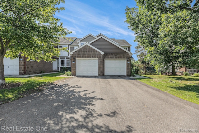 239 Fieldcrest St, Ann Arbor, MI 48103 - view of front of house featuring brick siding, asphalt driveway, an attached garage, and a front lawn