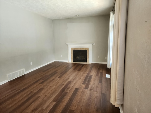 8270 Robins Ln, Battle Creek, MI 49014 - unfurnished living room with dark wood-type flooring, a fireplace, and a textured ceiling