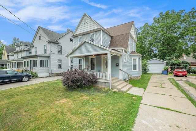 1607 Center Ave NE, Grand Rapids, MI 49505 - view of front facade featuring covered porch, a front lawn, a detached garage, and an outdoor structure