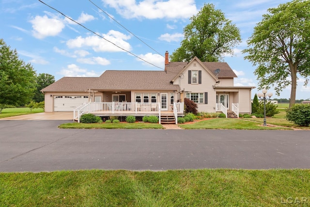 3224 Sand Creek Highway, Adrian, MI 49221 - traditional-style house featuring asphalt driveway, a chimney, an attached garage, and a front lawn