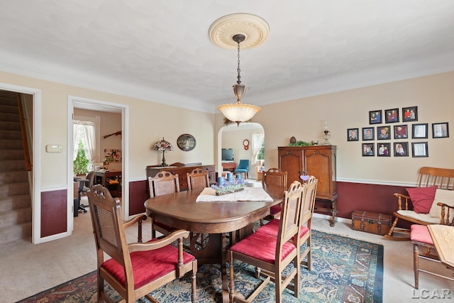 3224 Sand Creek Highway, Adrian, MI 49221 - carpeted dining space featuring arched walkways, stairs, and crown molding