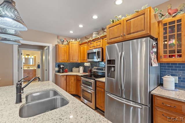 3224 Sand Creek Highway, Adrian, MI 49221 - kitchen featuring appliances with stainless steel finishes, brown cabinets, tasteful backsplash, light stone counters, and glass insert cabinets
