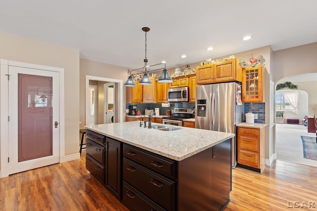 3224 Sand Creek Highway, Adrian, MI 49221 - kitchen with appliances with stainless steel finishes, light wood-type flooring, decorative backsplash, light stone countertops, and recessed lighting