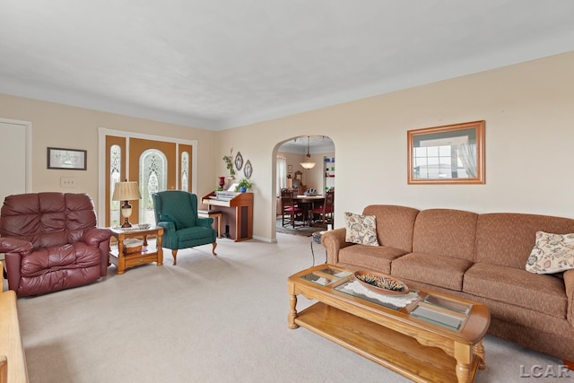 3224 Sand Creek Highway, Adrian, MI 49221 - living room featuring arched walkways, light colored carpet, and plenty of natural light