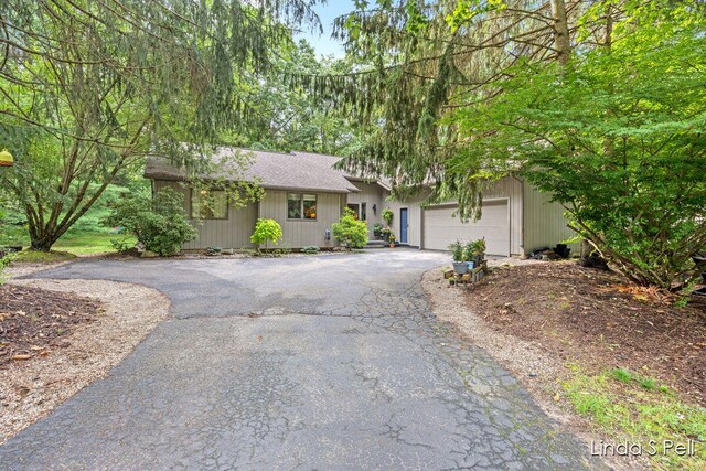 6636 E Riverwoods Ct NE, Rockford, MI 49341 - view of front of property with driveway, roof with shingles, and an attached garage