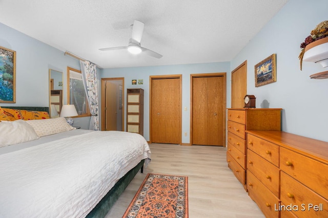 6636 E Riverwoods Ct NE, Rockford, MI 49341 - bedroom featuring multiple closets, light wood-type flooring, a textured ceiling, and ceiling fan