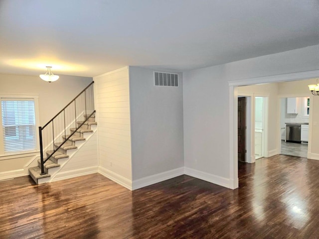 46 Lowell Ave NE, Grand Rapids, MI 49503 - unfurnished living room with wood finished floors, stairway, and a chandelier