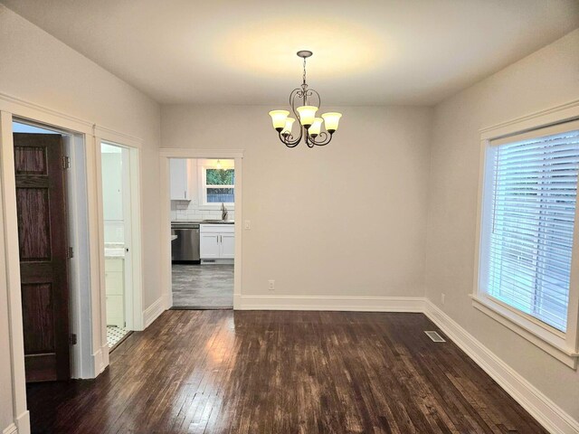 46 Lowell Ave NE, Grand Rapids, MI 49503 - unfurnished dining area with dark wood-style floors and a chandelier