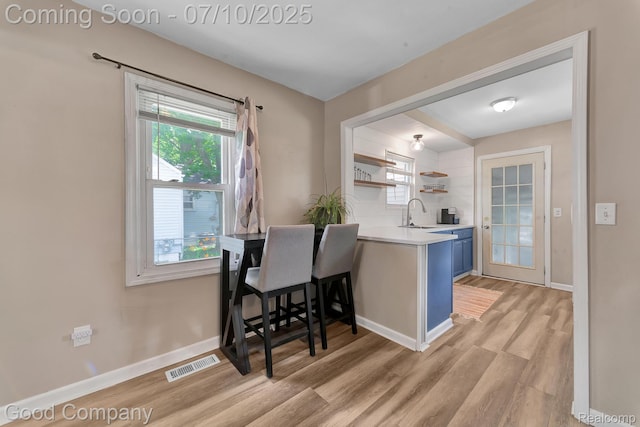 36149 Schley Ave, Van Buren, MI 48186 - kitchen featuring open shelves, blue cabinetry, light countertops, and light wood finished floors