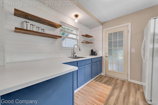 36149 Schley Ave, Van Buren, MI 48186 - kitchen featuring blue cabinets, freestanding refrigerator, open shelves, light wood-style floors, and light countertops
