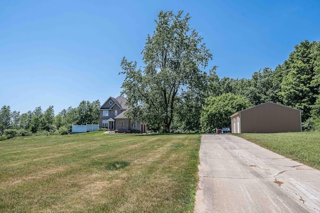4433 Elm St, New Era, MI 49446 - view of green lawn featuring an outdoor structure, driveway, and a garage