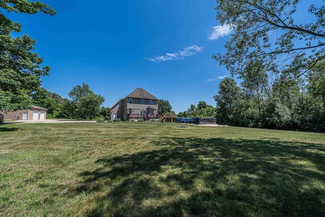 4433 Elm St, New Era, MI 49446 - view of green lawn featuring a detached garage