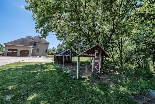 4433 Elm St, New Era, MI 49446 - view of poultry coop featuring a yard, concrete driveway, and an attached garage