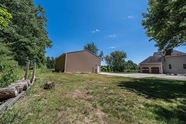 4433 Elm St, New Era, MI 49446 - view of grassy yard with a pole building, concrete driveway, a garage, and an outbuilding