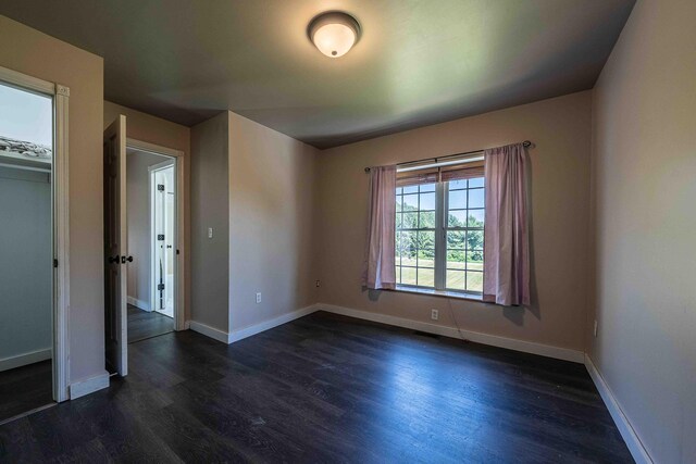 4433 Elm St, New Era, MI 49446 - empty room with dark wood-type flooring and baseboards