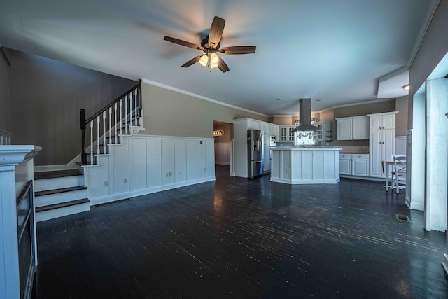 4433 Elm St, New Era, MI 49446 - unfurnished living room with a ceiling fan, dark wood-style flooring, crown molding, and stairs