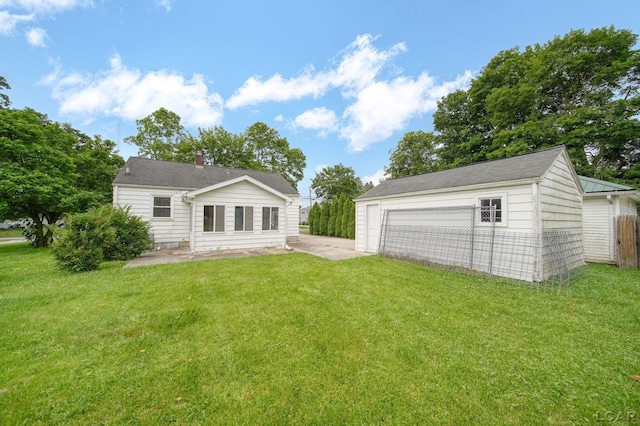 309 E Logan St, Tecumseh, MI 49286 - back of property with a patio, an outdoor structure, a garage, and a chimney