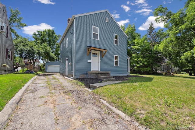 1516 Gainey Ave, Flint, MI 48503 - view of front of house featuring a chimney, an outdoor structure, a front yard, a detached garage, and asphalt driveway