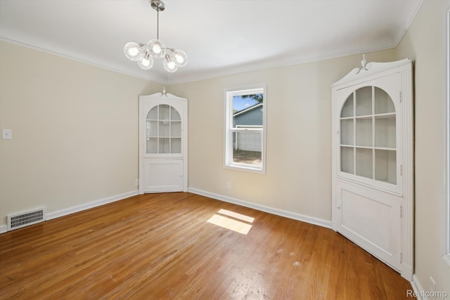 1516 Gainey Ave, Flint, MI 48503 - unfurnished dining area with a chandelier, light wood-style flooring, and ornamental molding
