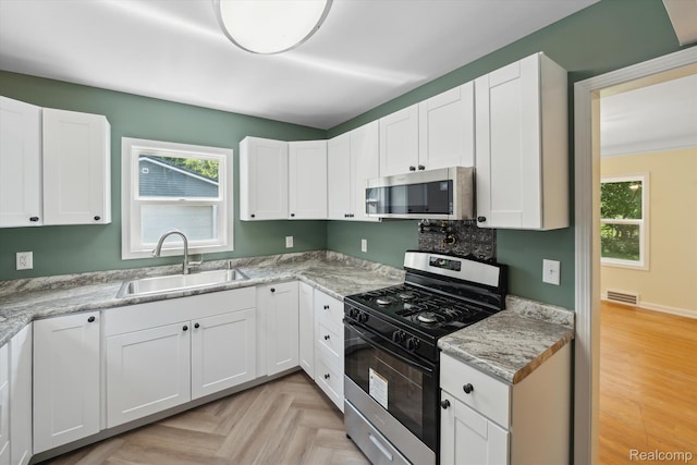 1516 Gainey Ave, Flint, MI 48503 - kitchen with appliances with stainless steel finishes and white cabinets