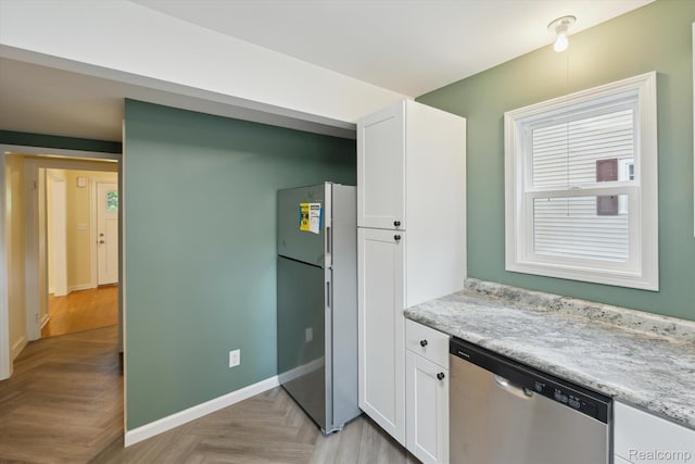 1516 Gainey Ave, Flint, MI 48503 - kitchen with freestanding refrigerator, stainless steel dishwasher, and white cabinetry