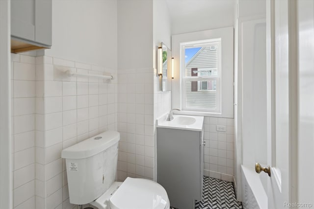 1516 Gainey Ave, Flint, MI 48503 - bathroom featuring tile walls, vanity, a tub, a wainscoted wall, and tile patterned flooring