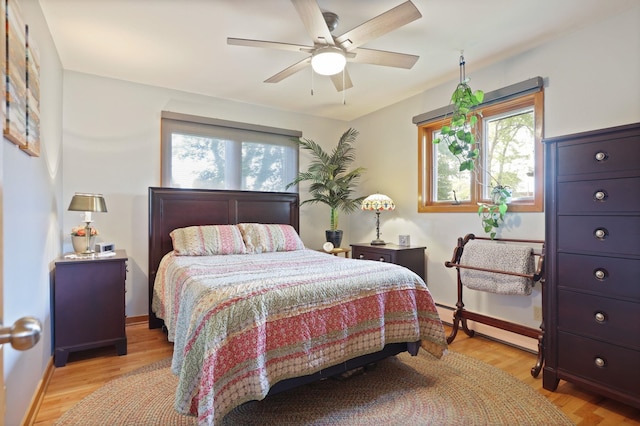 120 Sunburst Dr, Frankenmuth, MI 48734 - bedroom featuring multiple windows, baseboard heating, light wood finished floors, and ceiling fan
