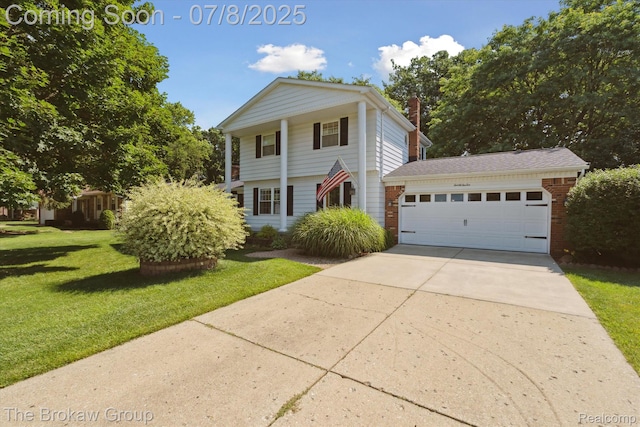 2210 Old Hickory Blvd, Davison, MI 48423 - neoclassical / greek revival house with a front yard, an attached garage, concrete driveway, brick siding, and a chimney